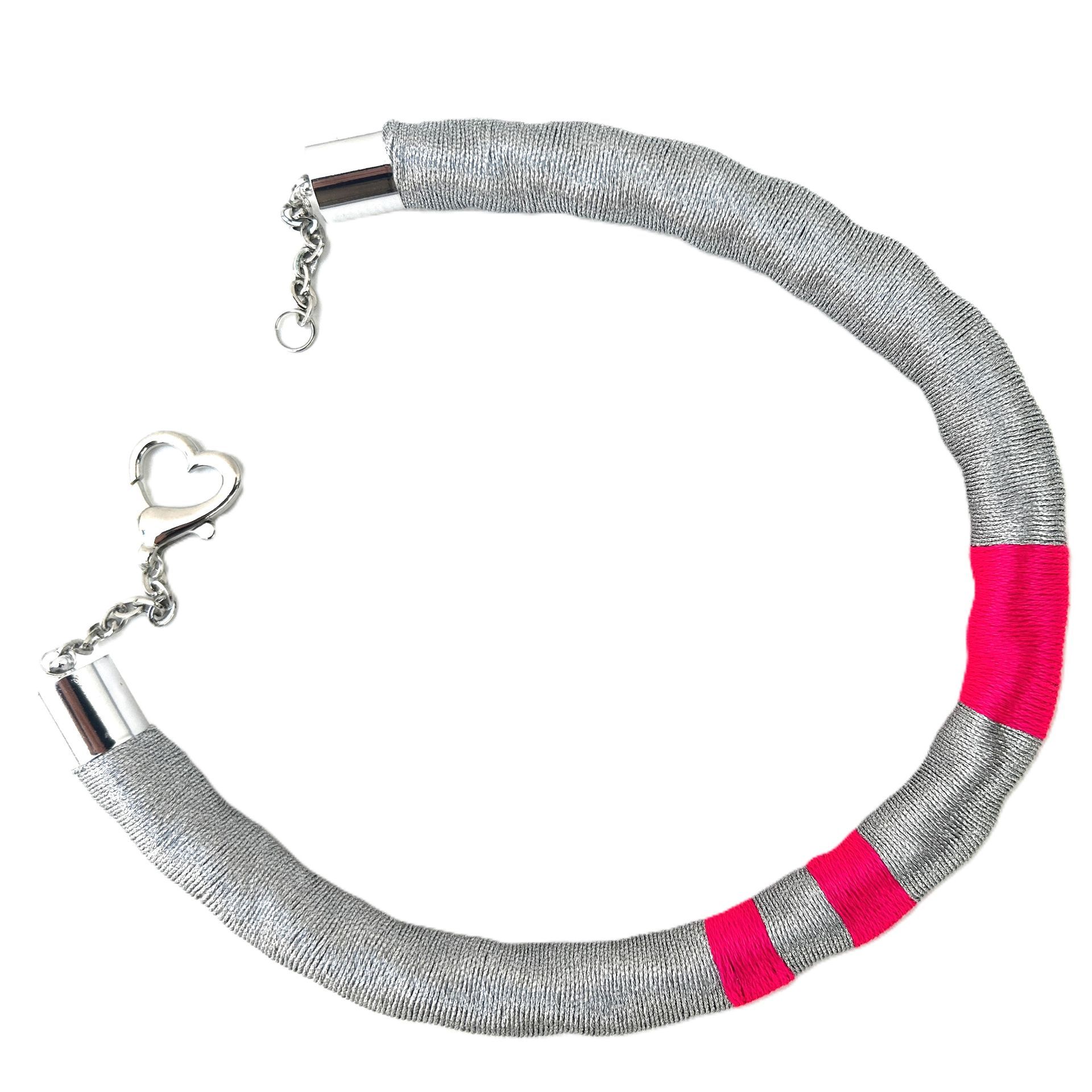 Un collar de plata y rosa con un cierre en forma de corazón.