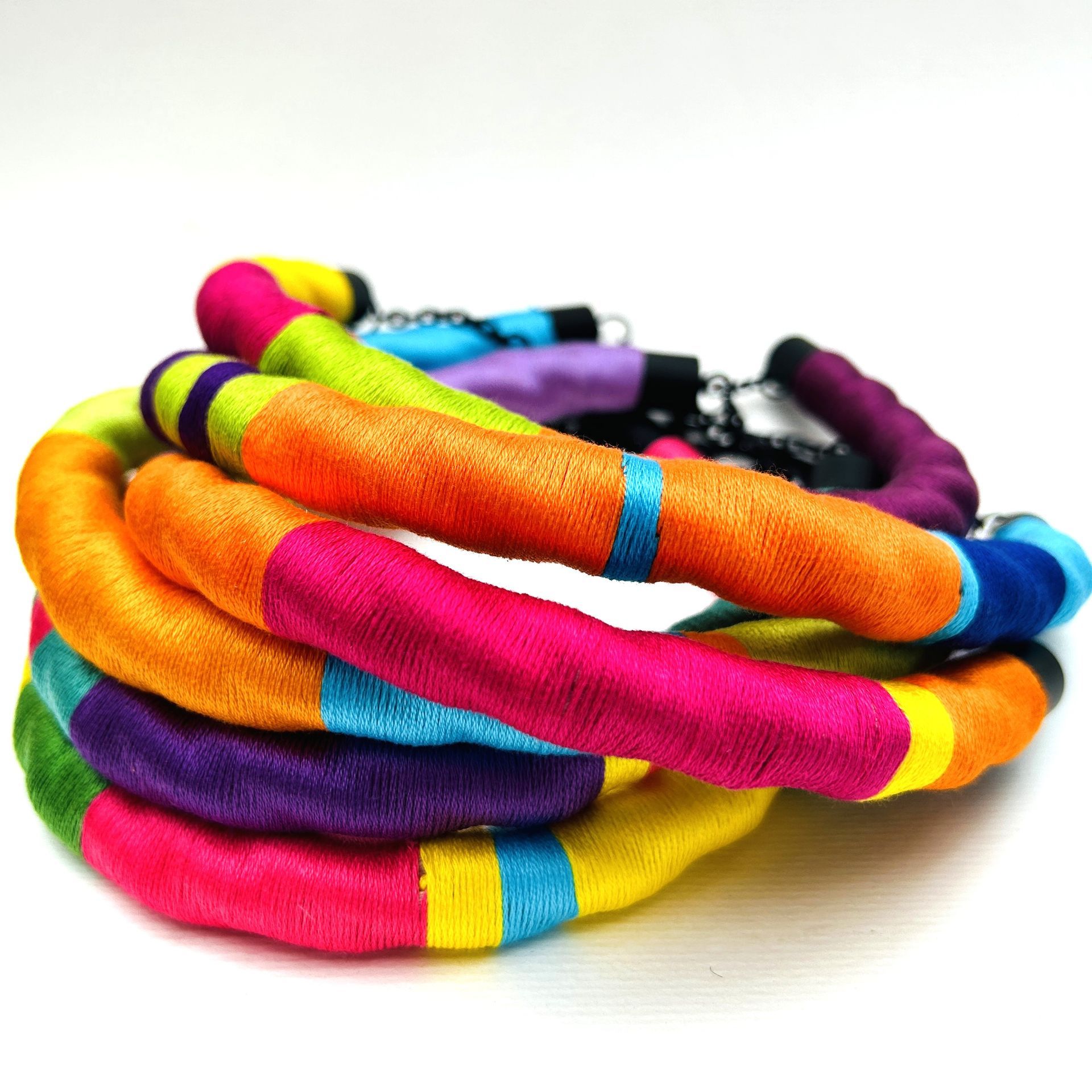 Un montón de pulseras de colores se apilan una encima de otra.