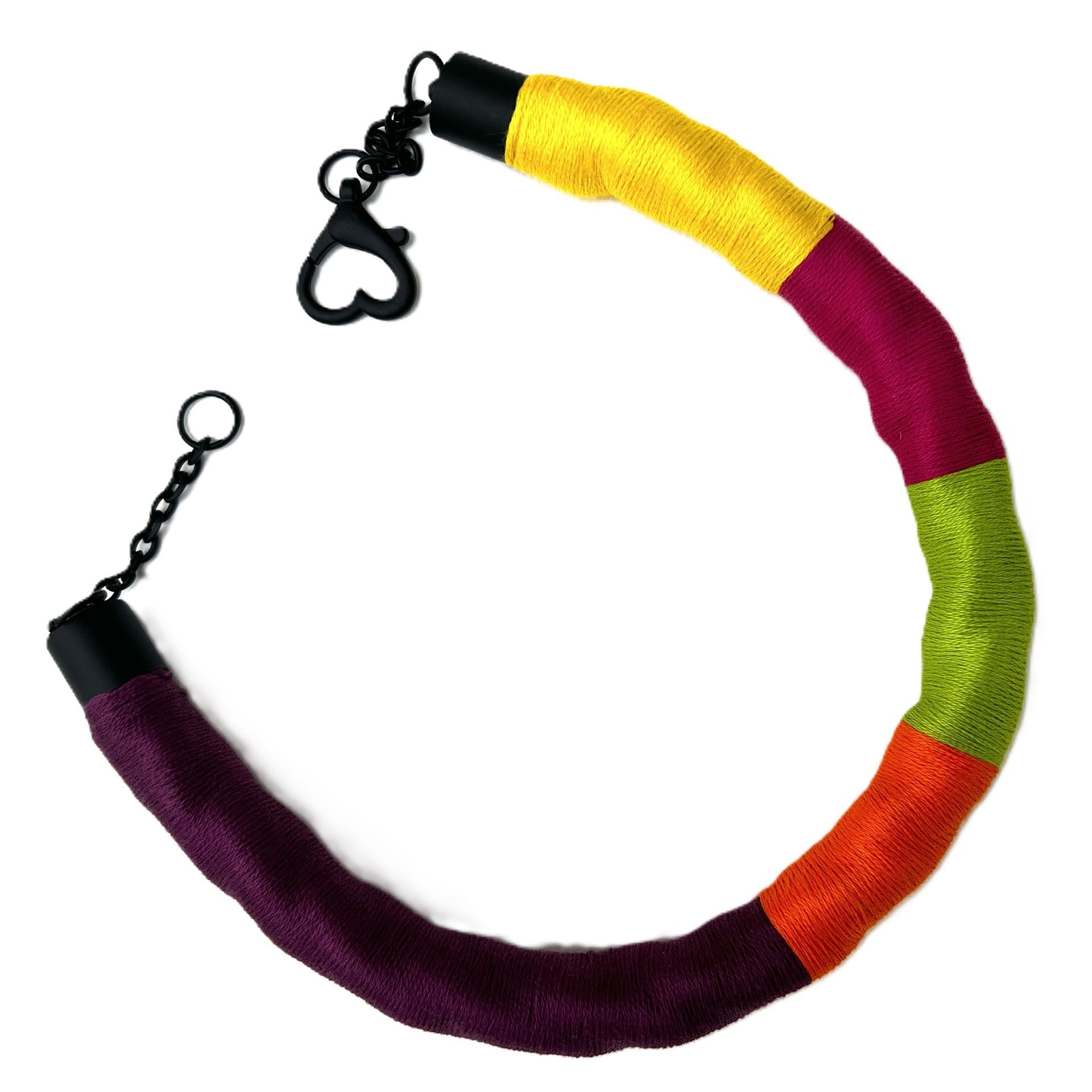 Una pulsera colorida con un cierre en forma de corazón negro.