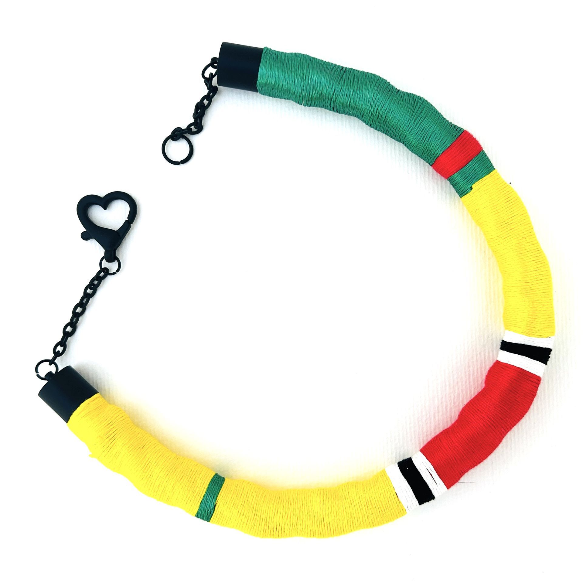 Un collar amarillo, verde y rojo con un cierre en forma de corazón.