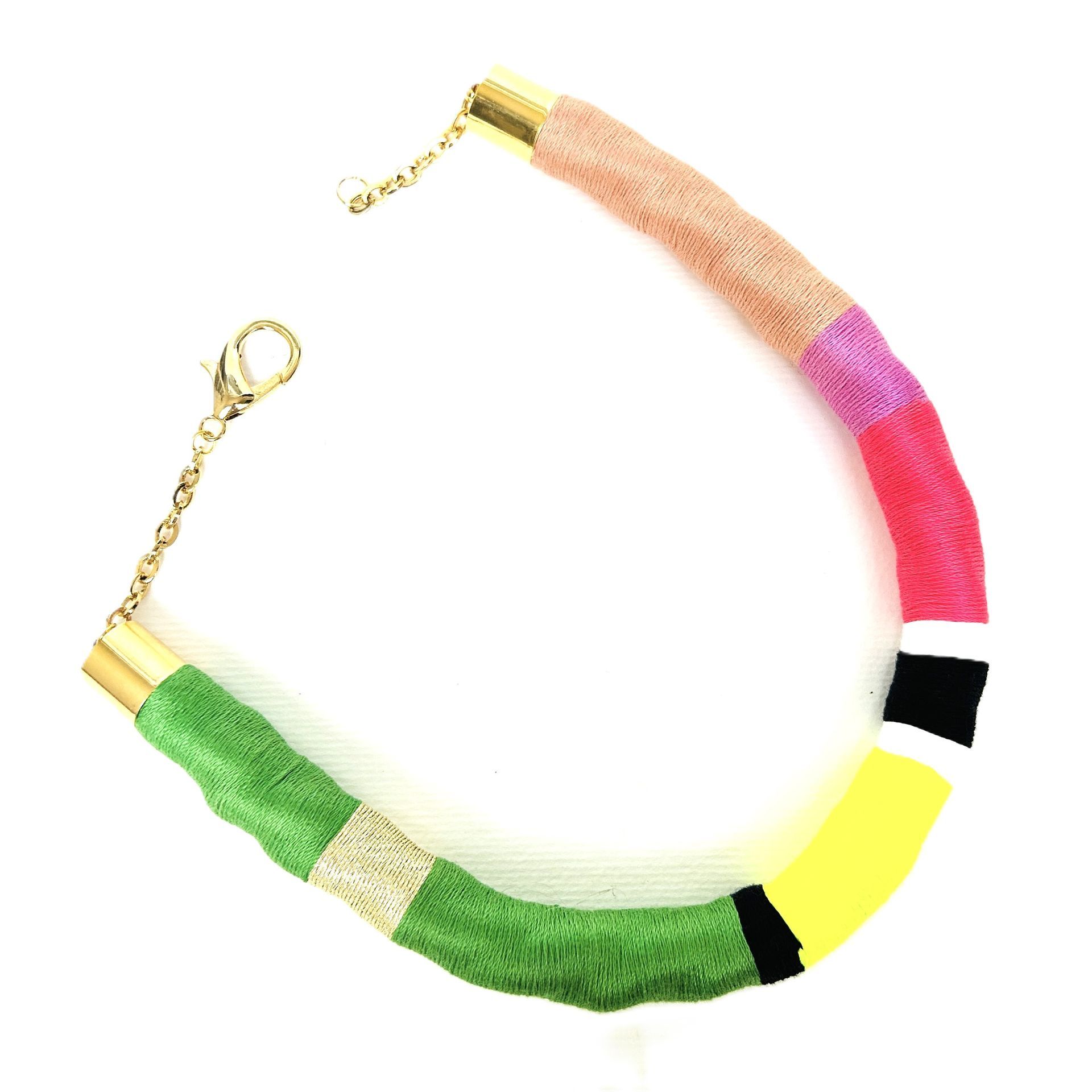 Un collar colorido con un cierre dorado sobre un fondo blanco.