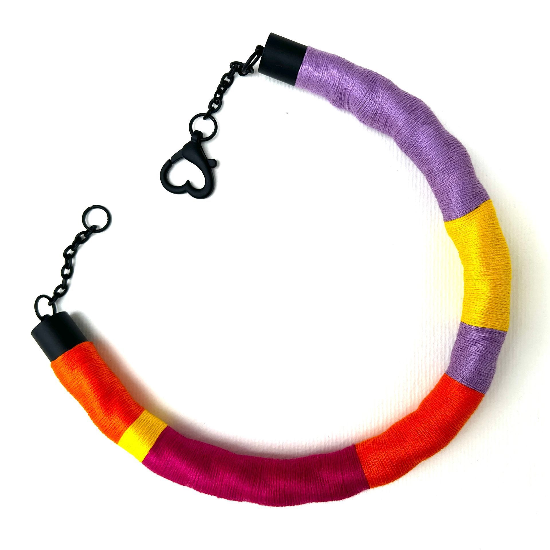 Un collar morado, amarillo y naranja con un cierre negro.