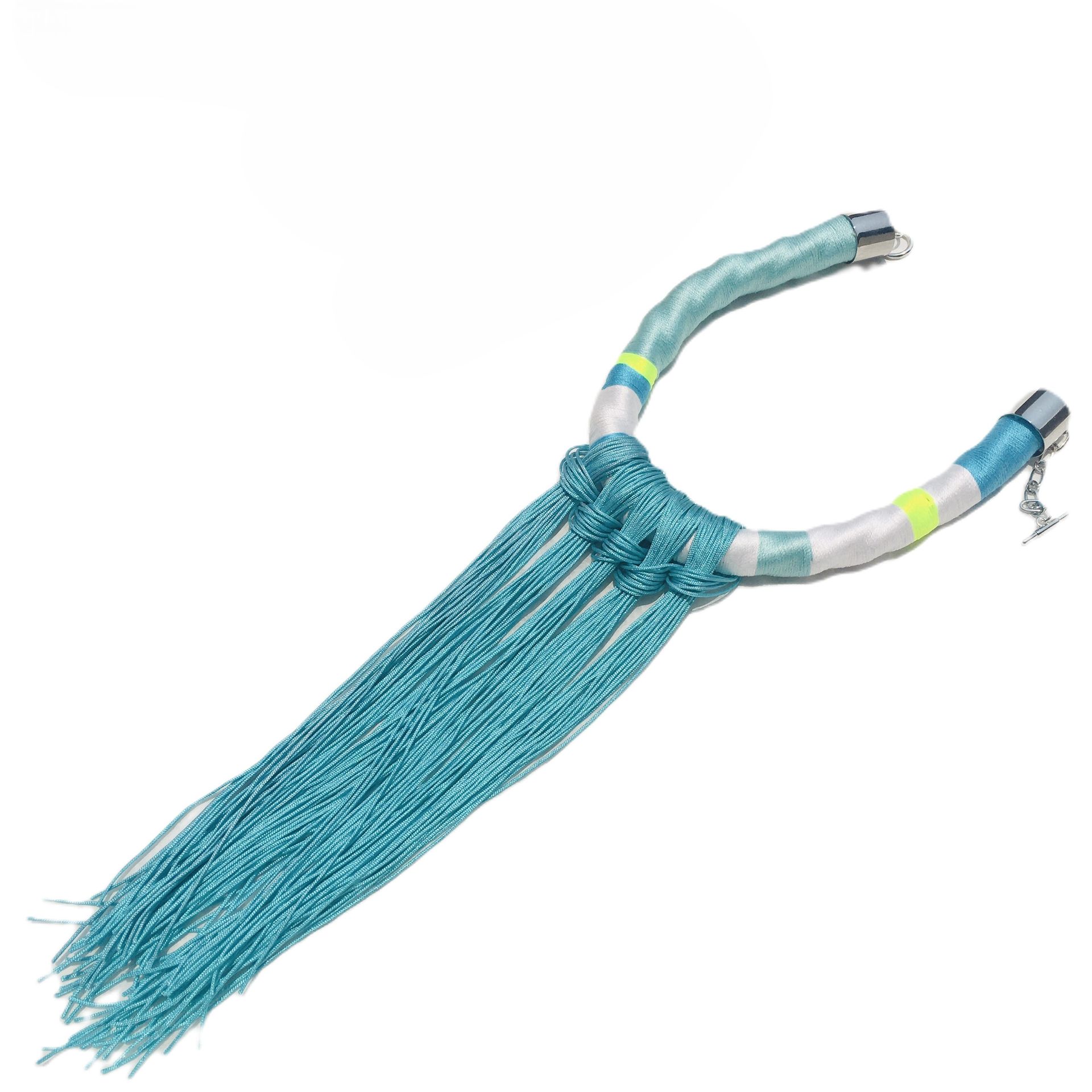 Un collar azul y blanco con flecos sobre un fondo blanco.