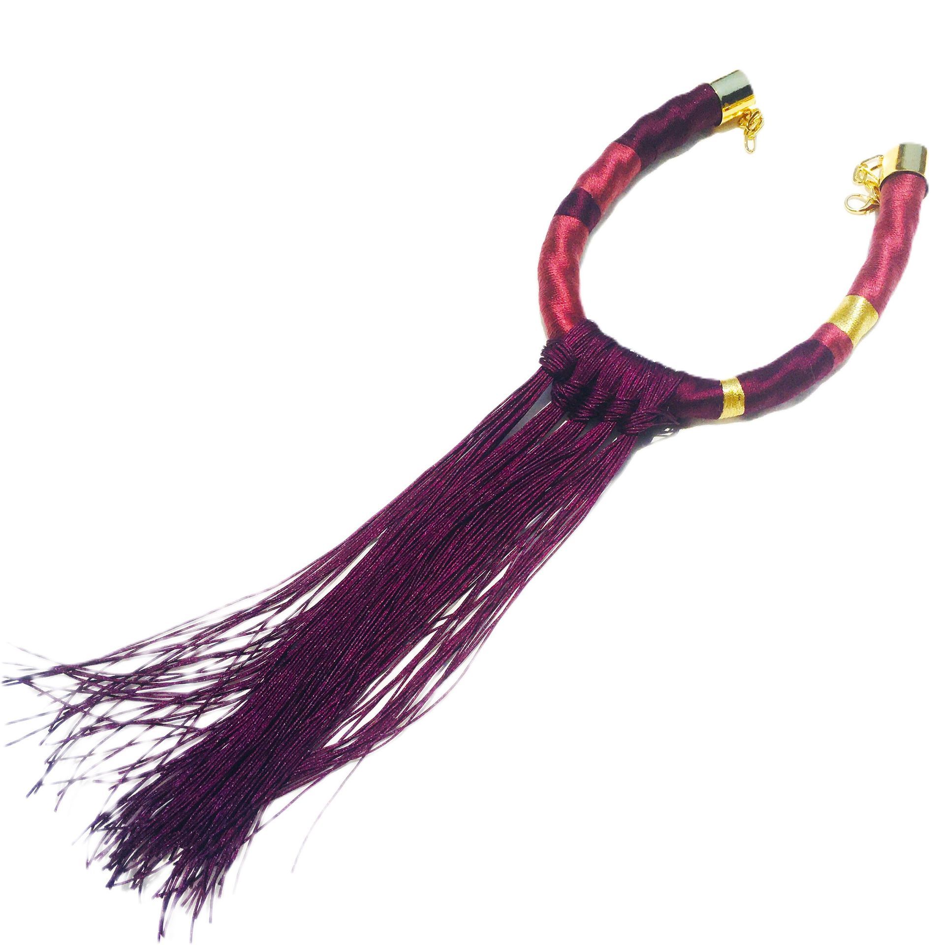 Un collar morado y rojo con un cierre dorado.