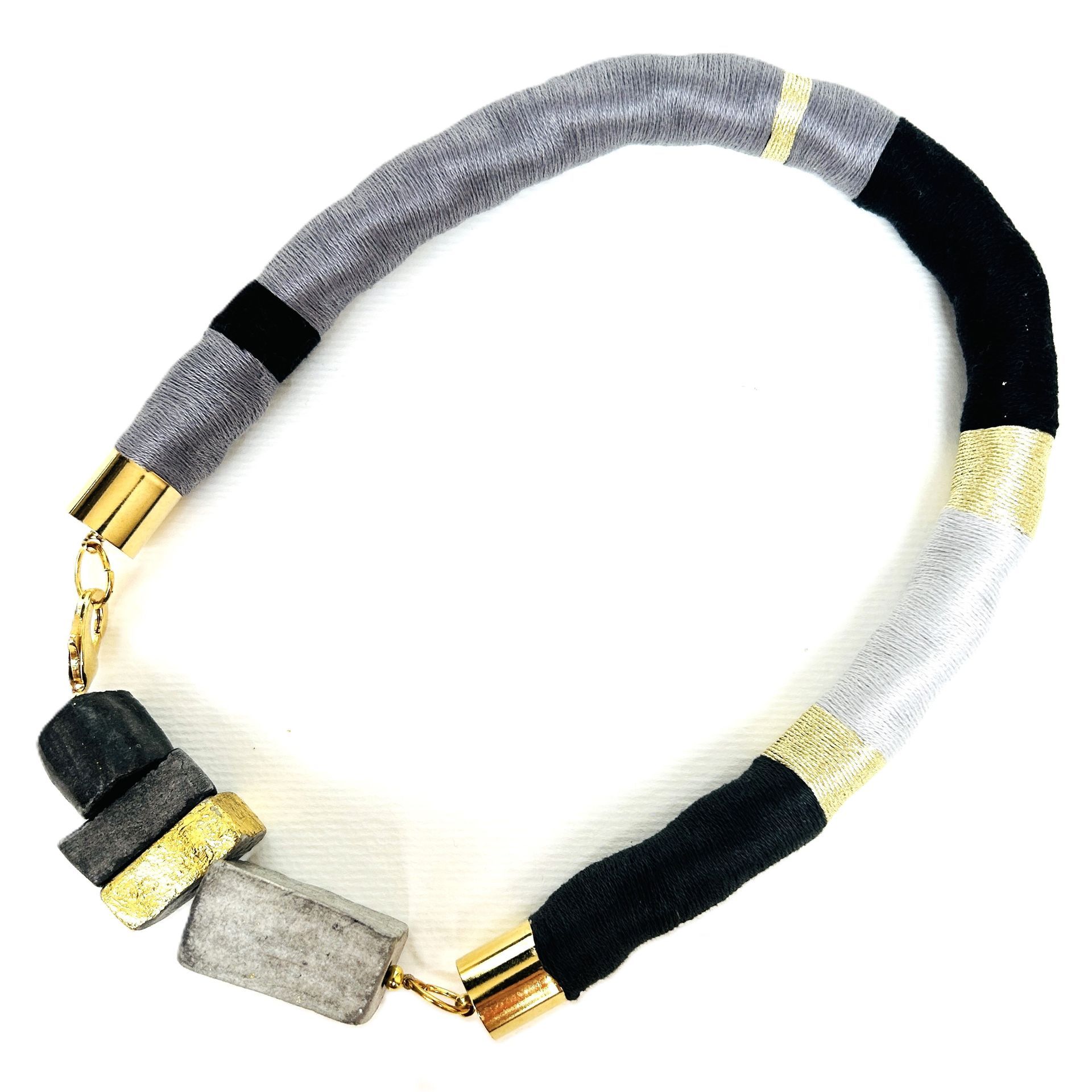 Un collar blanco y negro con un cierre dorado.