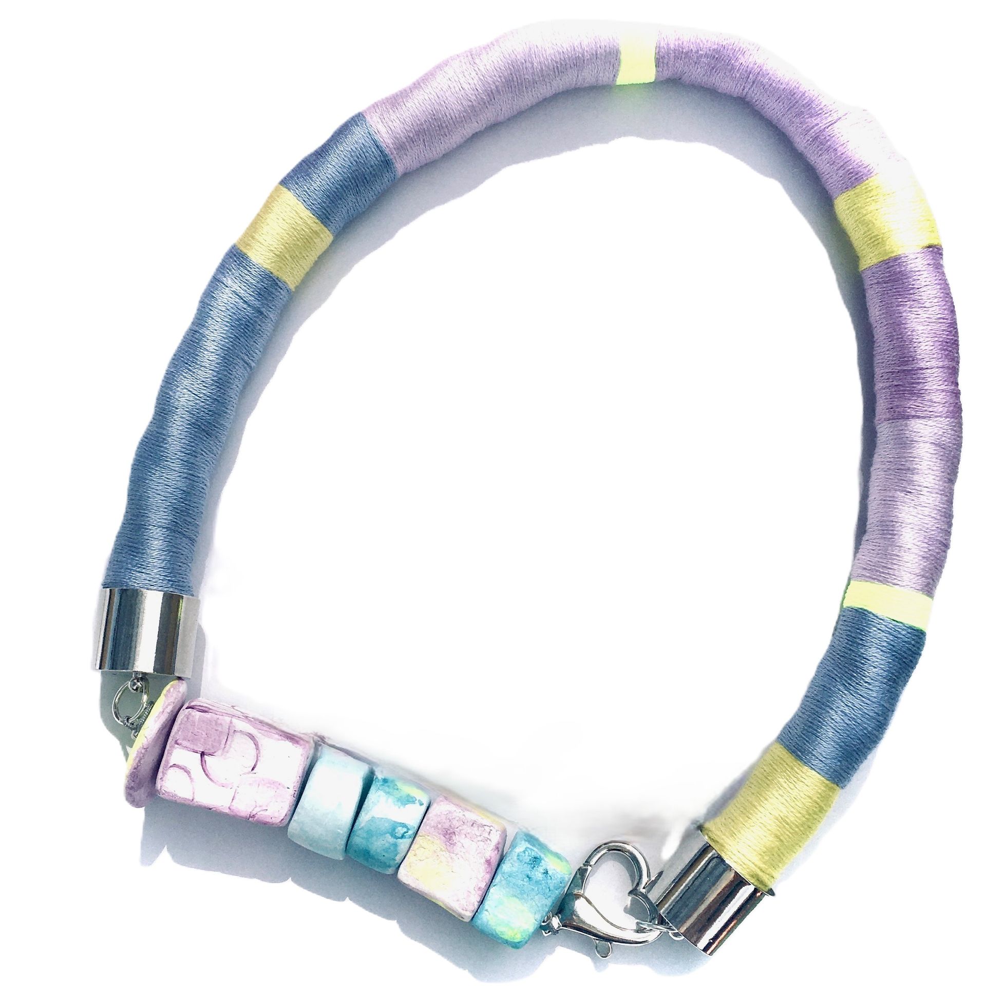 Una pulsera con cuentas moradas y azules sobre un fondo blanco.