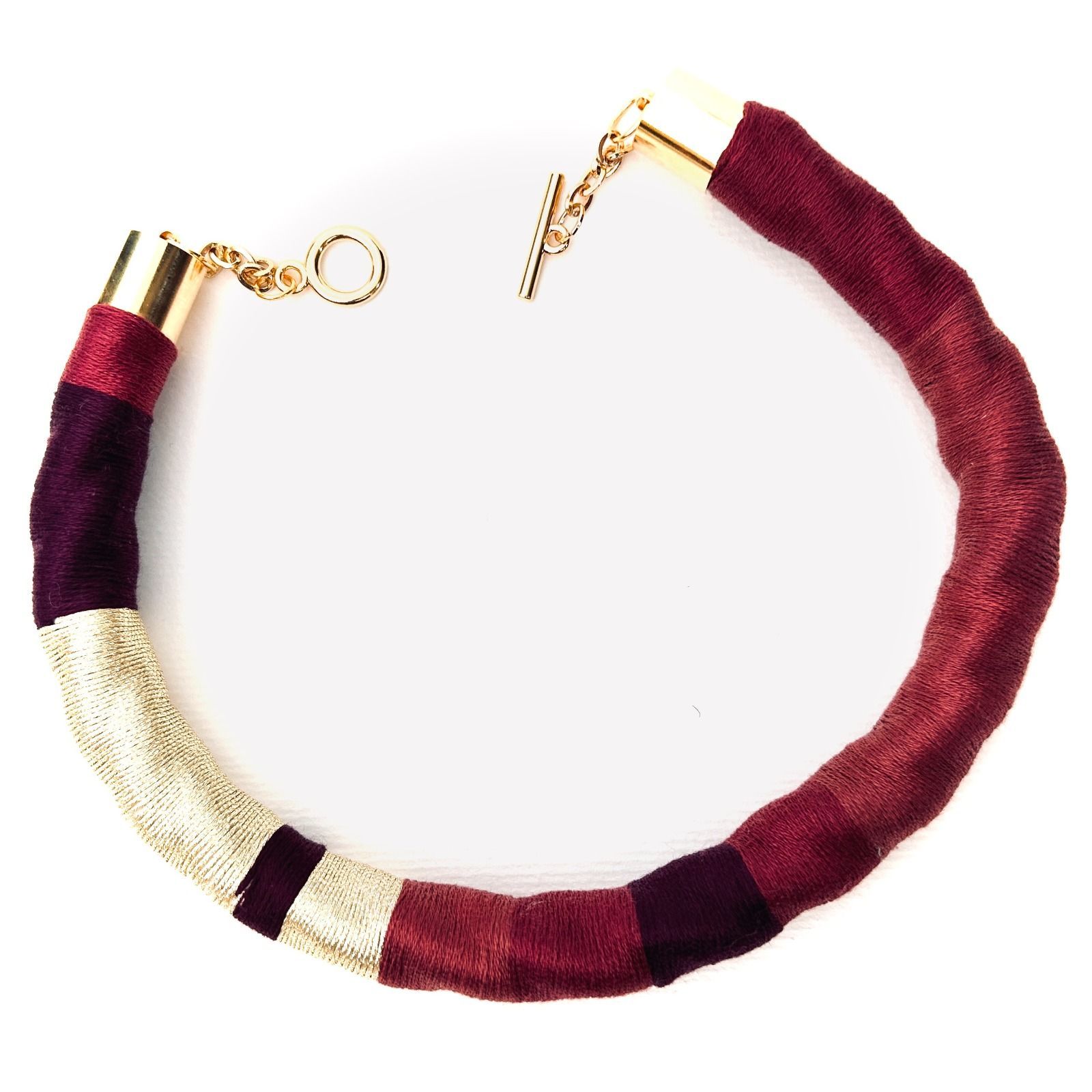 Una pulsera roja y dorada con cierres dorados.