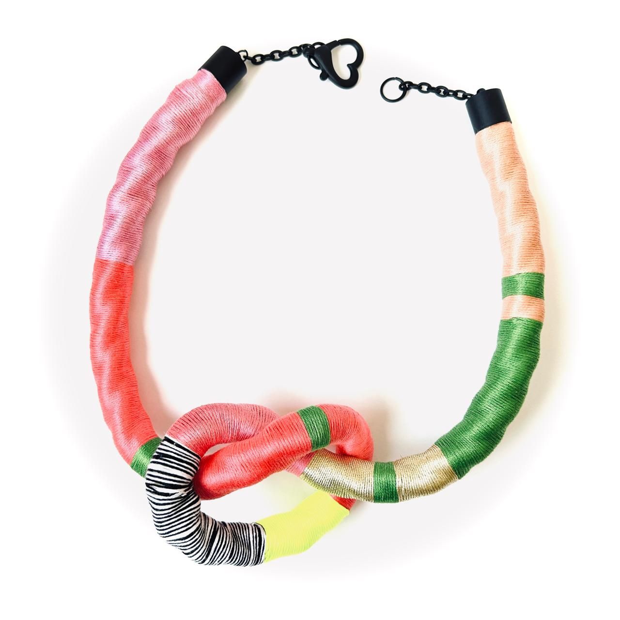 Un collar colorido con un cierre dorado sobre un fondo blanco.