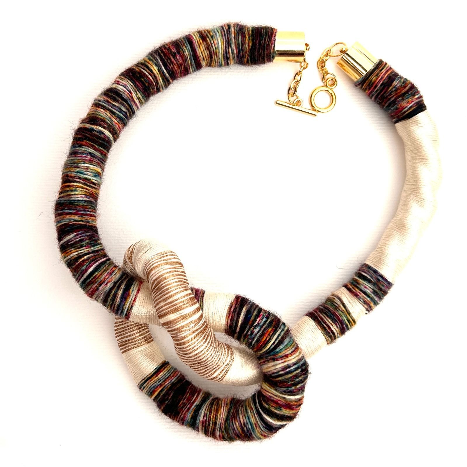 Un collar verde y dorado con un cierre dorado.