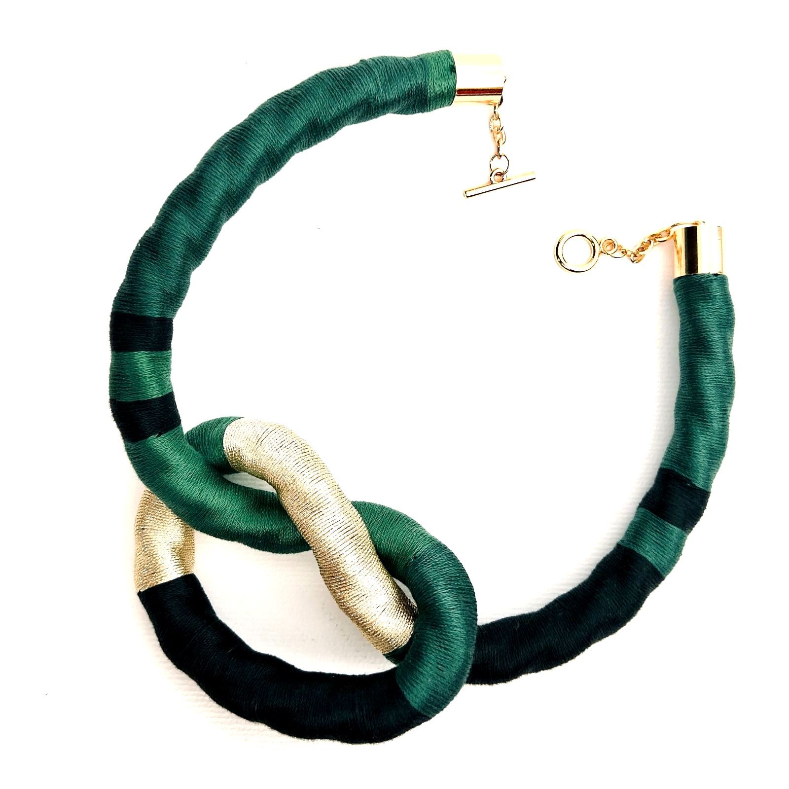 Un collar verde y dorado con un cierre dorado.