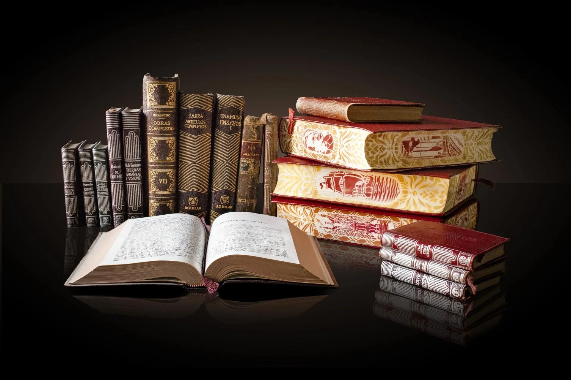 A stack of books on a table with an open book in the middle