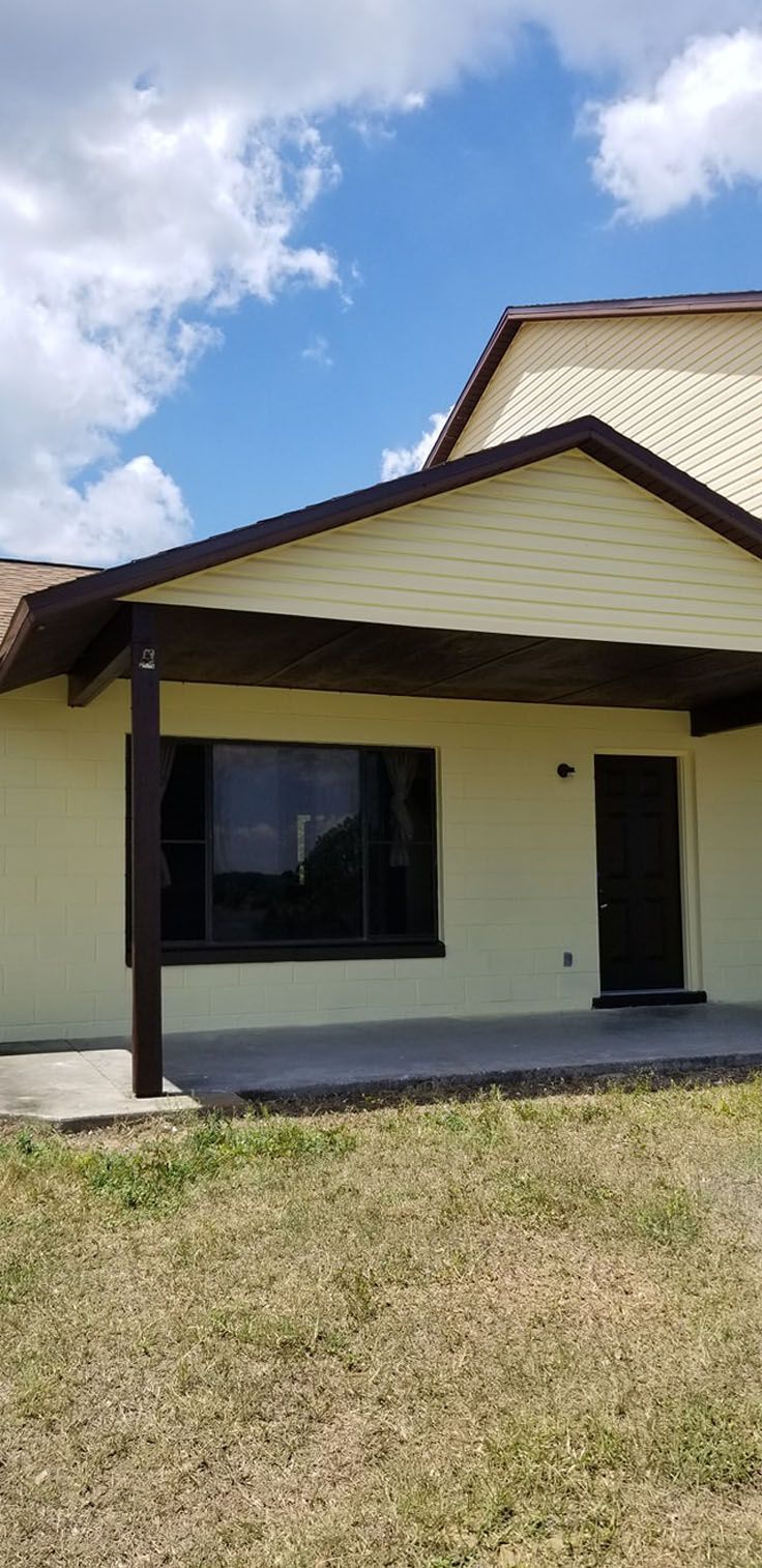 Exterior of a light yellow house with a porch