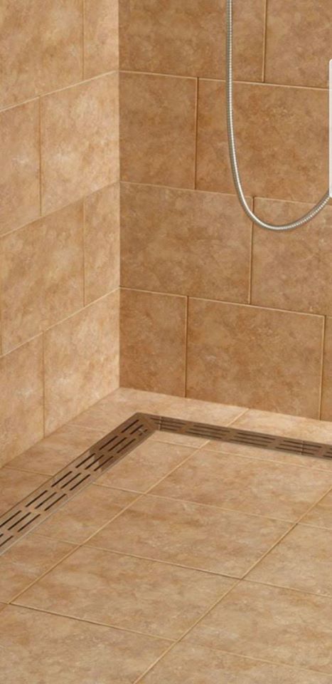 Shower stall with brown tile, stainless steel drain, and showerhead