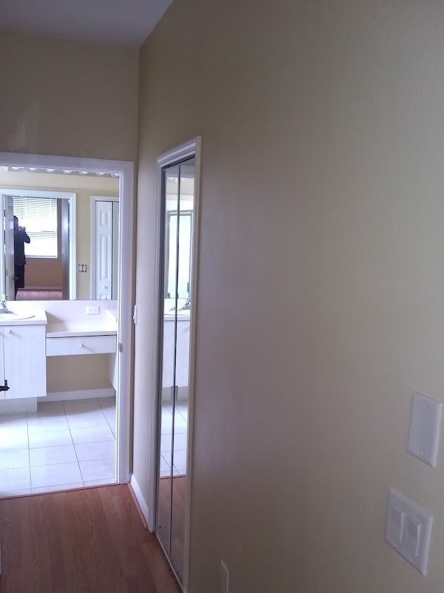 Hallway with open doorway to bathroom and mirrored closet