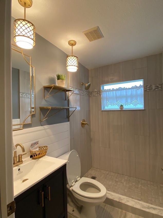 Bathroom with gold fixtures, blue walls, and light-colored tile
