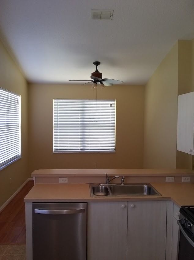 Kitchen with a sink, dishwasher, and blinds on the windows