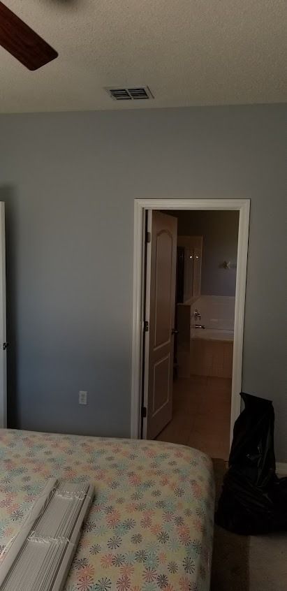 Bedroom with a bed, open doorway leading to a bathroom