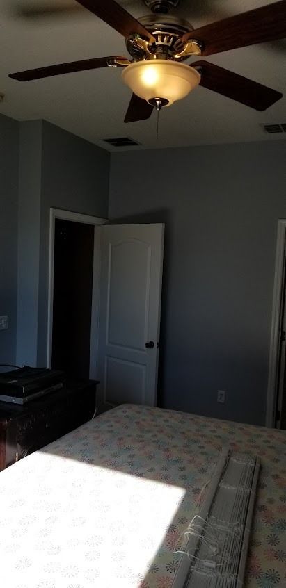 Bedroom with ceiling fan, bed, and open doorway