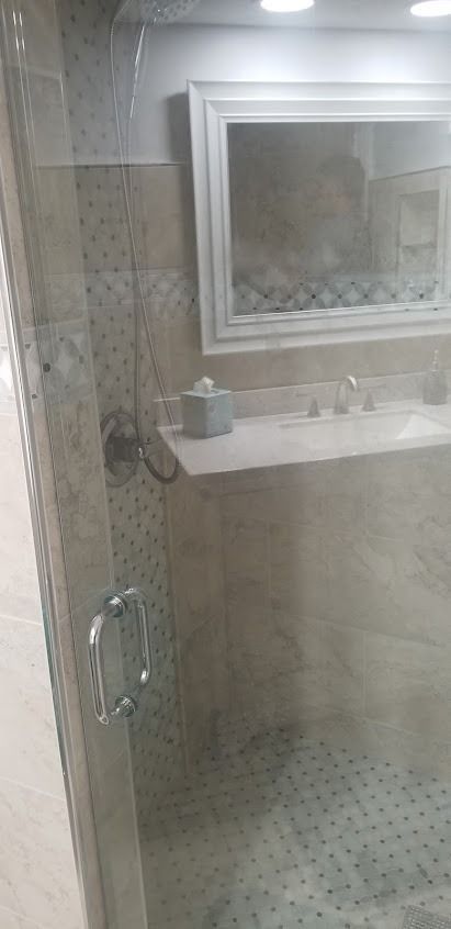 Bathroom interior with a glass shower, vanity, and mirror
