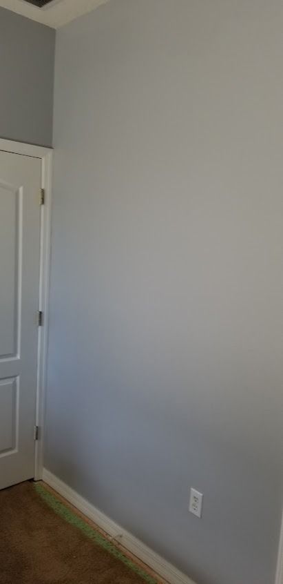 Gray walls, white door, and a light switch on the right