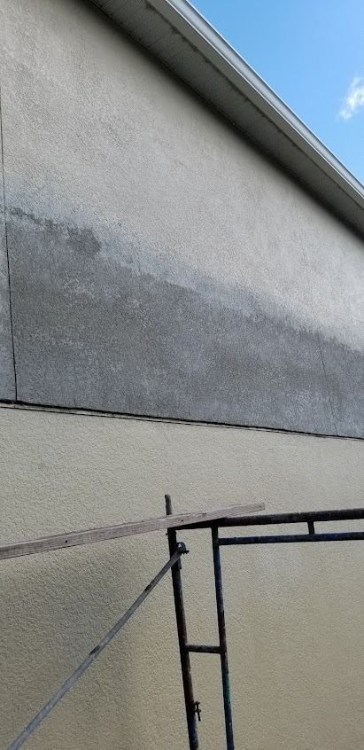 Exterior wall with dark stain and scaffolding.