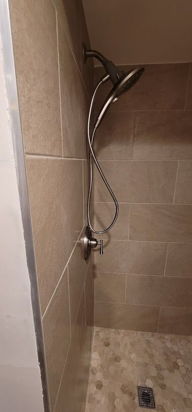 A shower with a dual showerhead and pebble floor