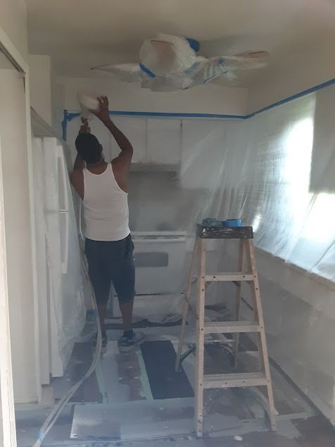 Person painting kitchen ceiling
