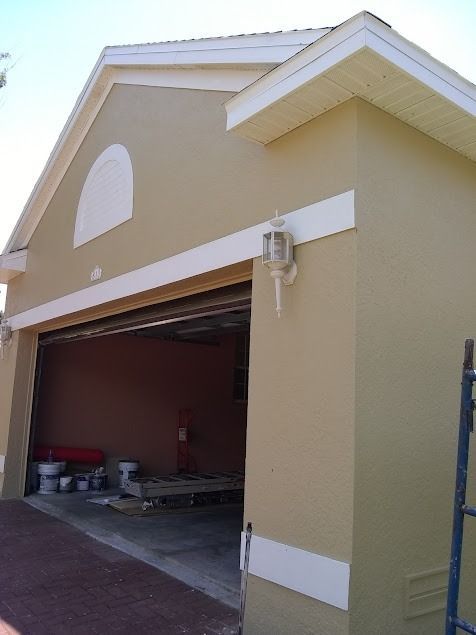 Tan garage with open door, white trim, and a red interior