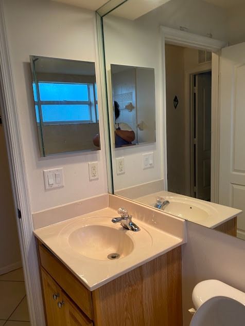 Bathroom with sink, mirror, and toilet
