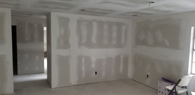 Interior of a room under construction, drywall installed, walls and ceiling primed