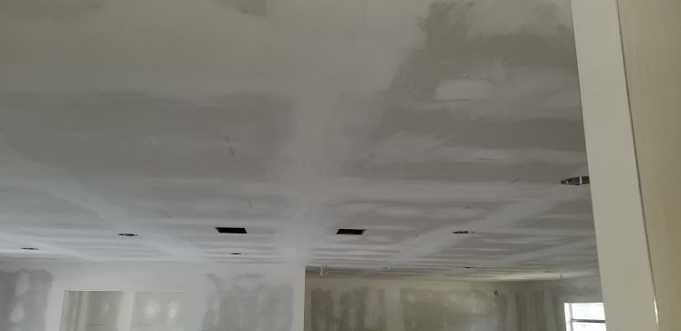 An unfinished room with a partially drywalled ceiling