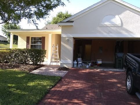 House exterior with red brick driveway, garage open with paint supplies