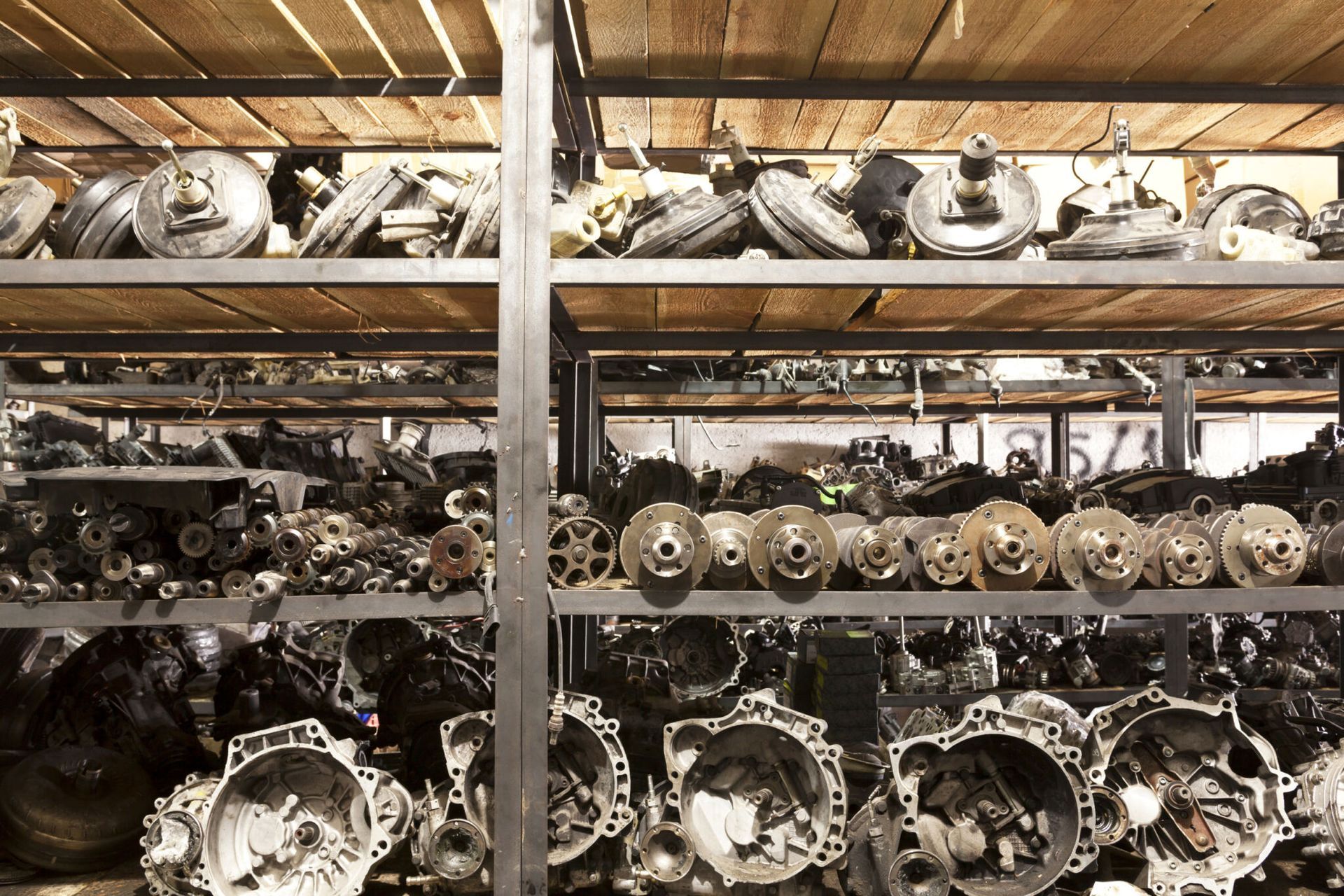Shelves filled with various car parts, including gears, housings, and wheels, in a warehouse setting. - Crypto Parts In Tuggerah, NSW