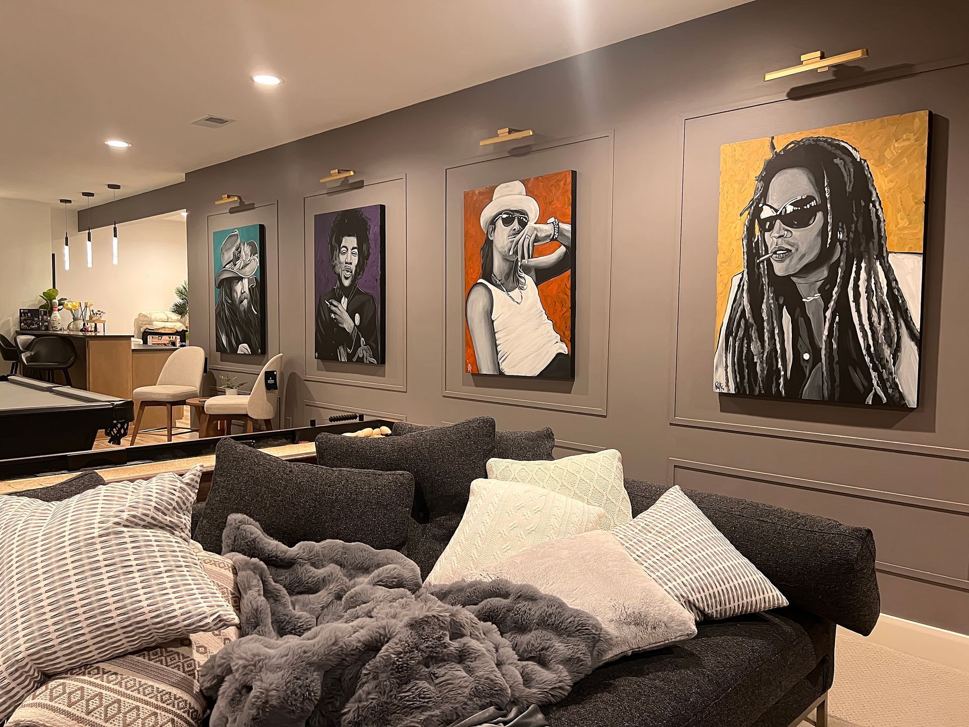Modern living room with framed dog portraits above a sofa and a coffee table in the foreground