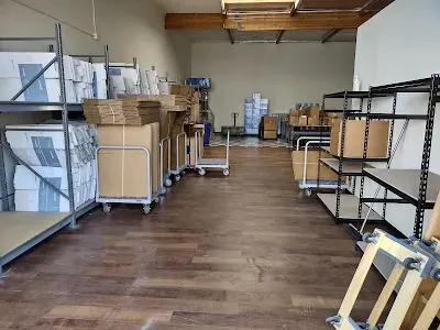 Warehouse interior with shelves, boxes, and a wooden floor.