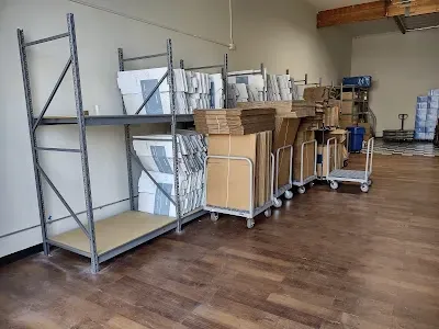 Warehouse interior with metal shelving holding boxes. Cardboard boxes on rolling carts line the room.