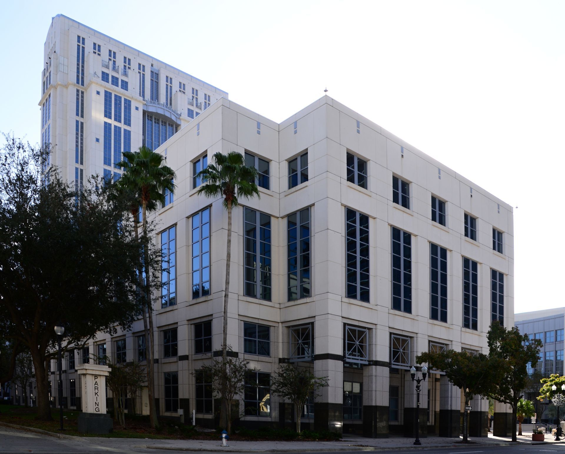Man in light blue shirt walks in living room with furniture, boxes.