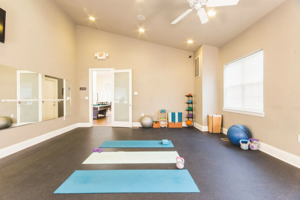 There are three yoga mats in the middle of the room.