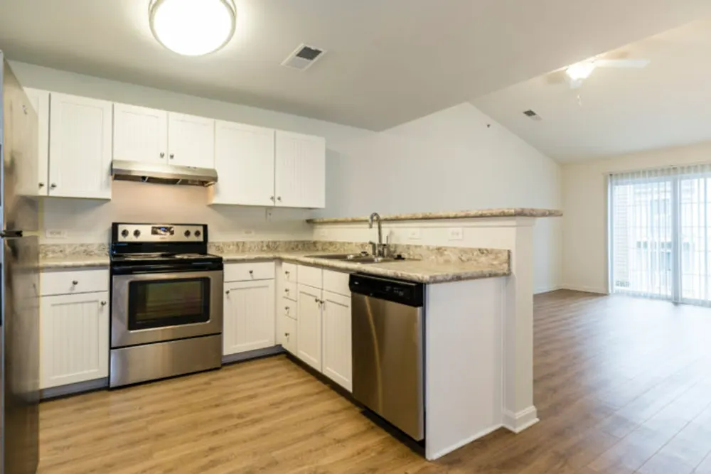 A kitchen with stainless steel appliances and white cabinets.