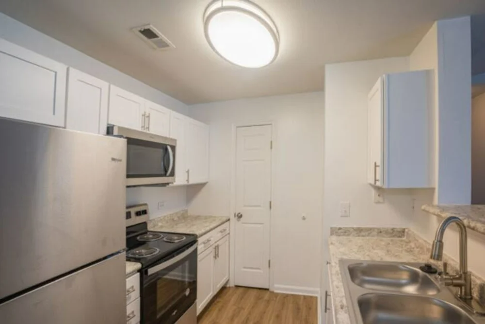 A kitchen with stainless steel appliances and white cabinets.