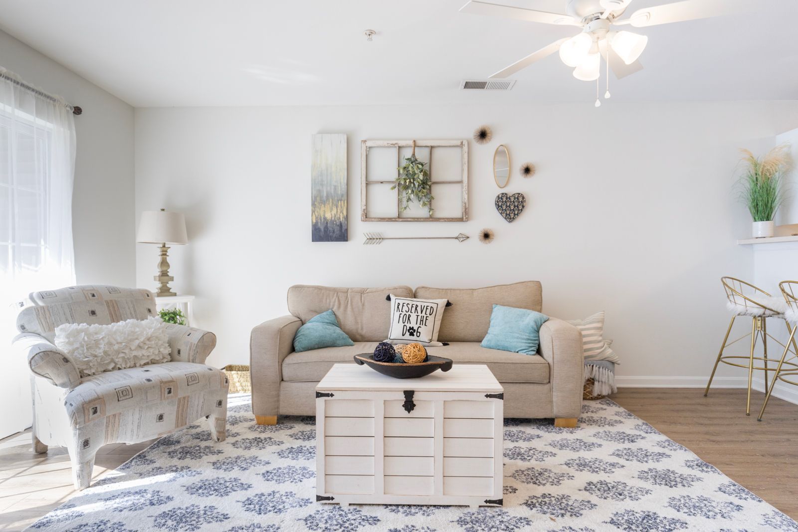 A living room with a couch, chair, coffee table, and ceiling fan.