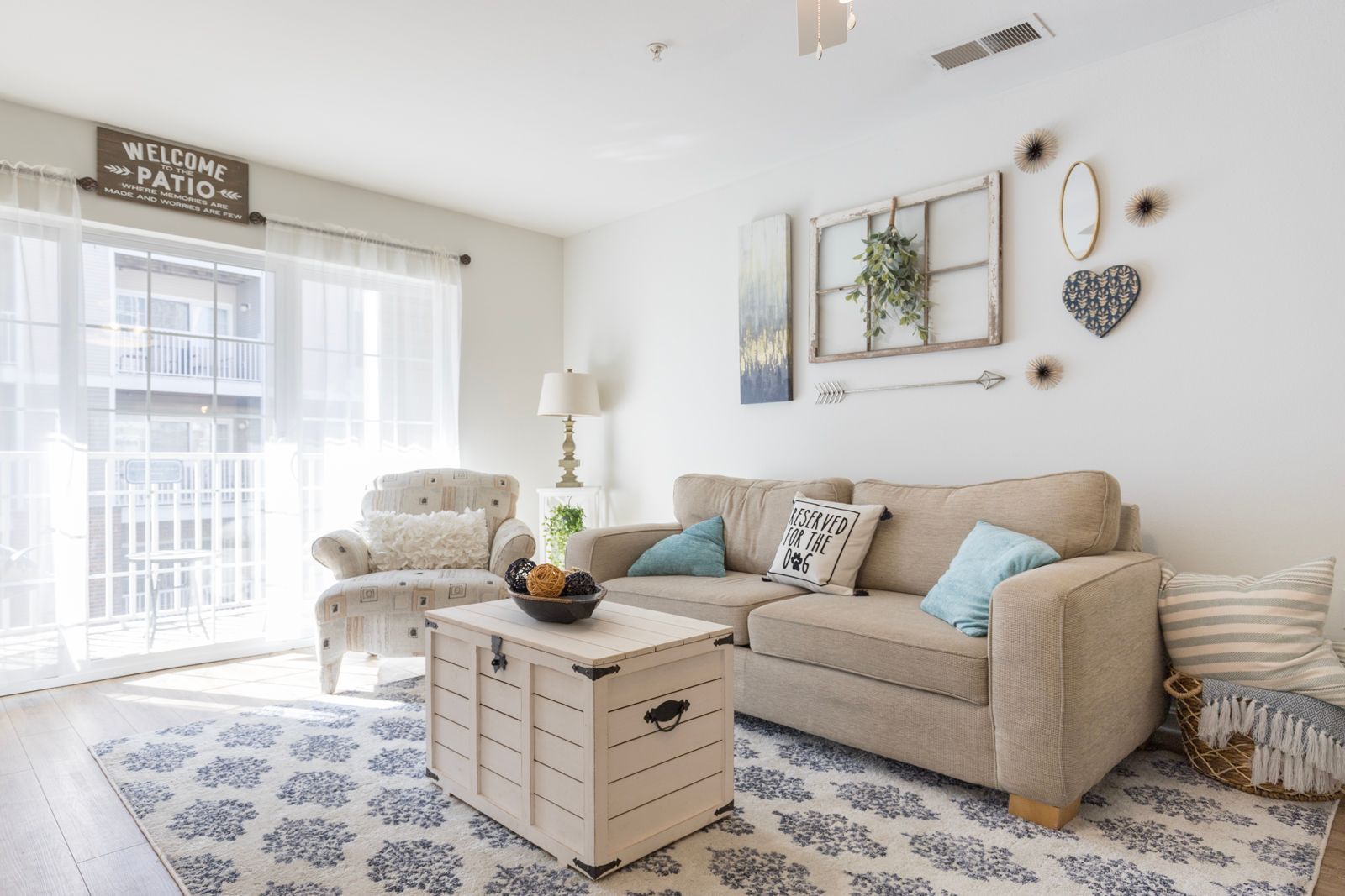 A living room with a couch , chair , coffee table and rug.