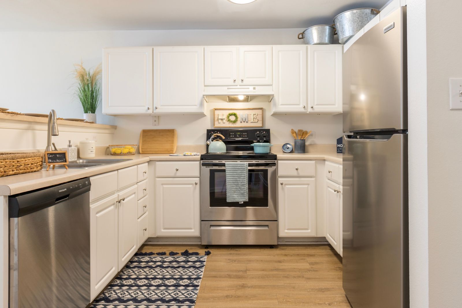 A kitchen with white cabinets and stainless steel appliances.