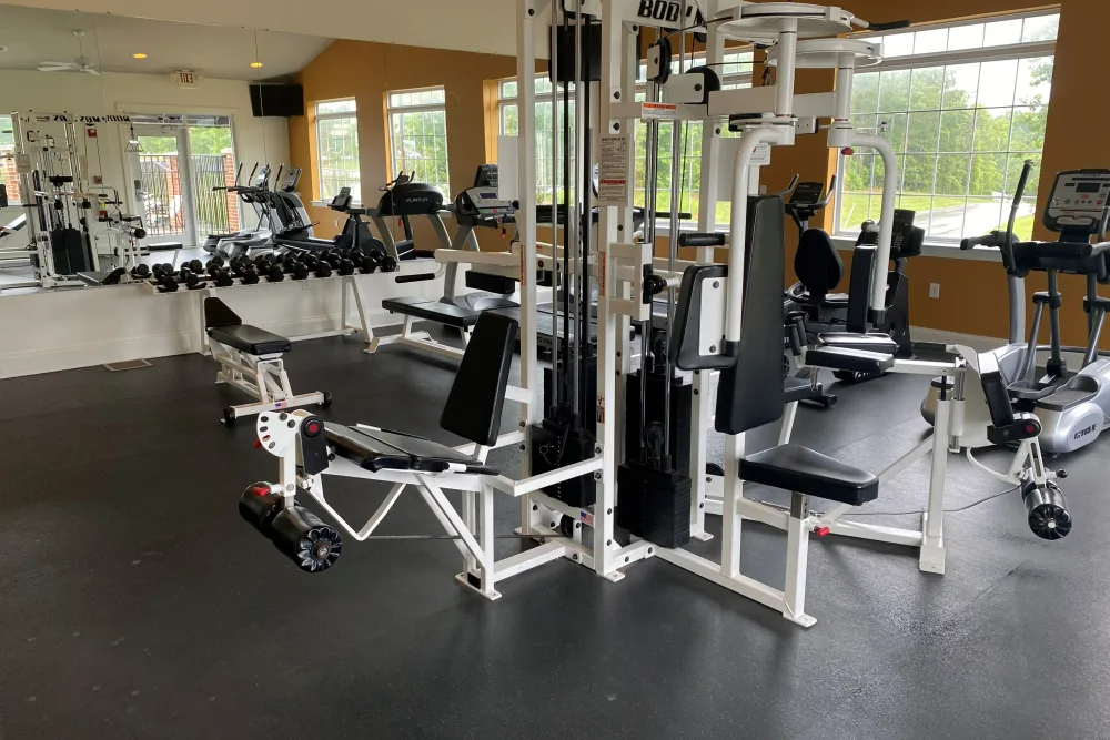 A large gym filled with lots of exercise equipment.