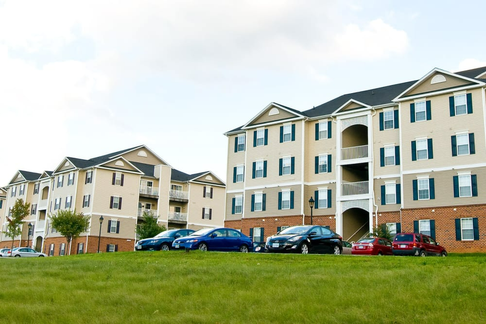 A large apartment building with cars parked in front of it