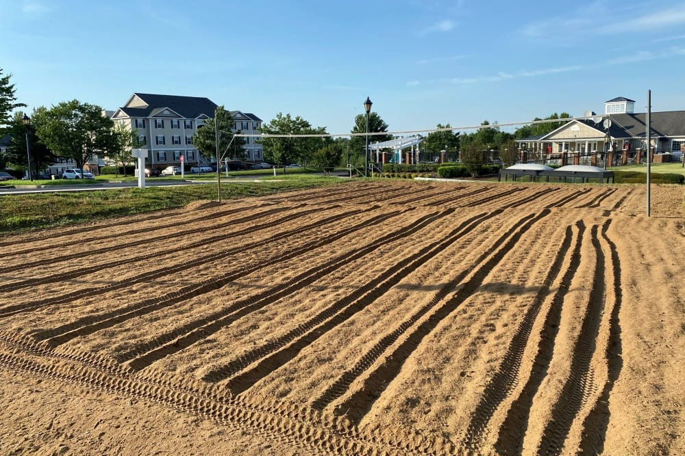 A field of dirt with apartment buildings in the background