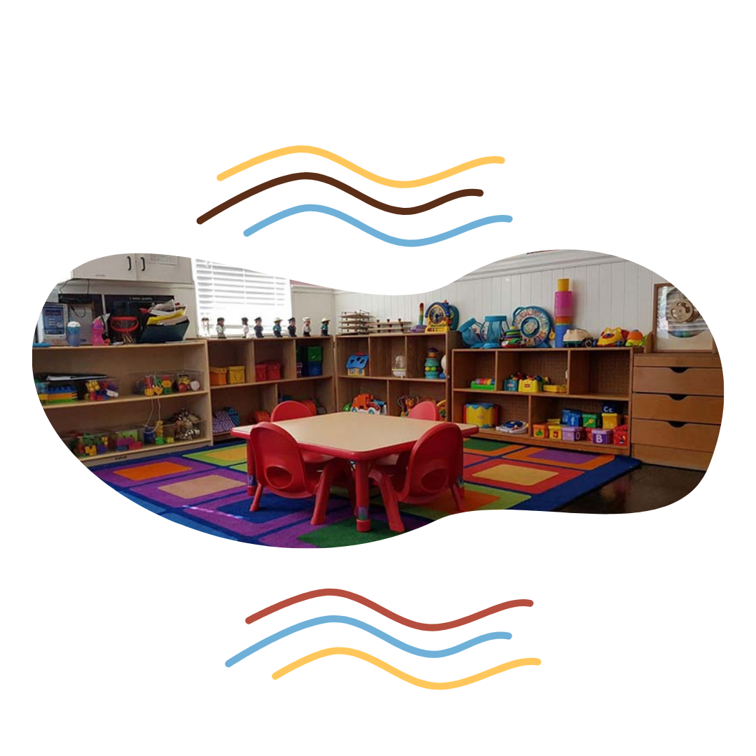 A classroom filled with lots of toys and a table and chairs.