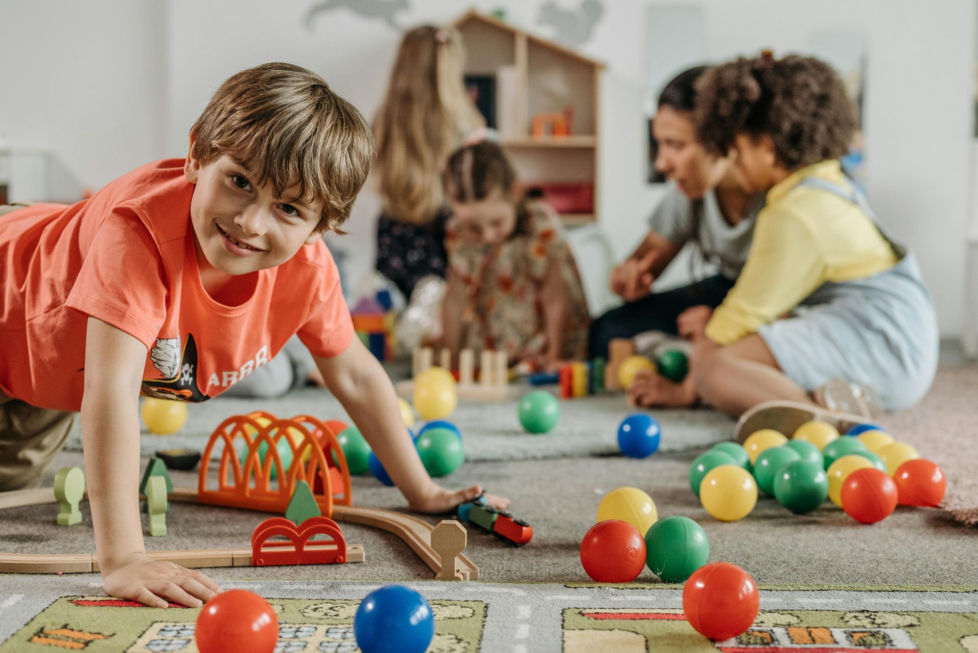 A group of children are playing with toys on the floor.