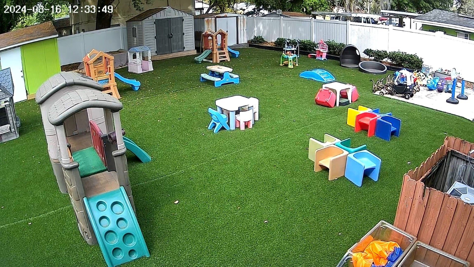 A playground with tables , chairs , and a slide.