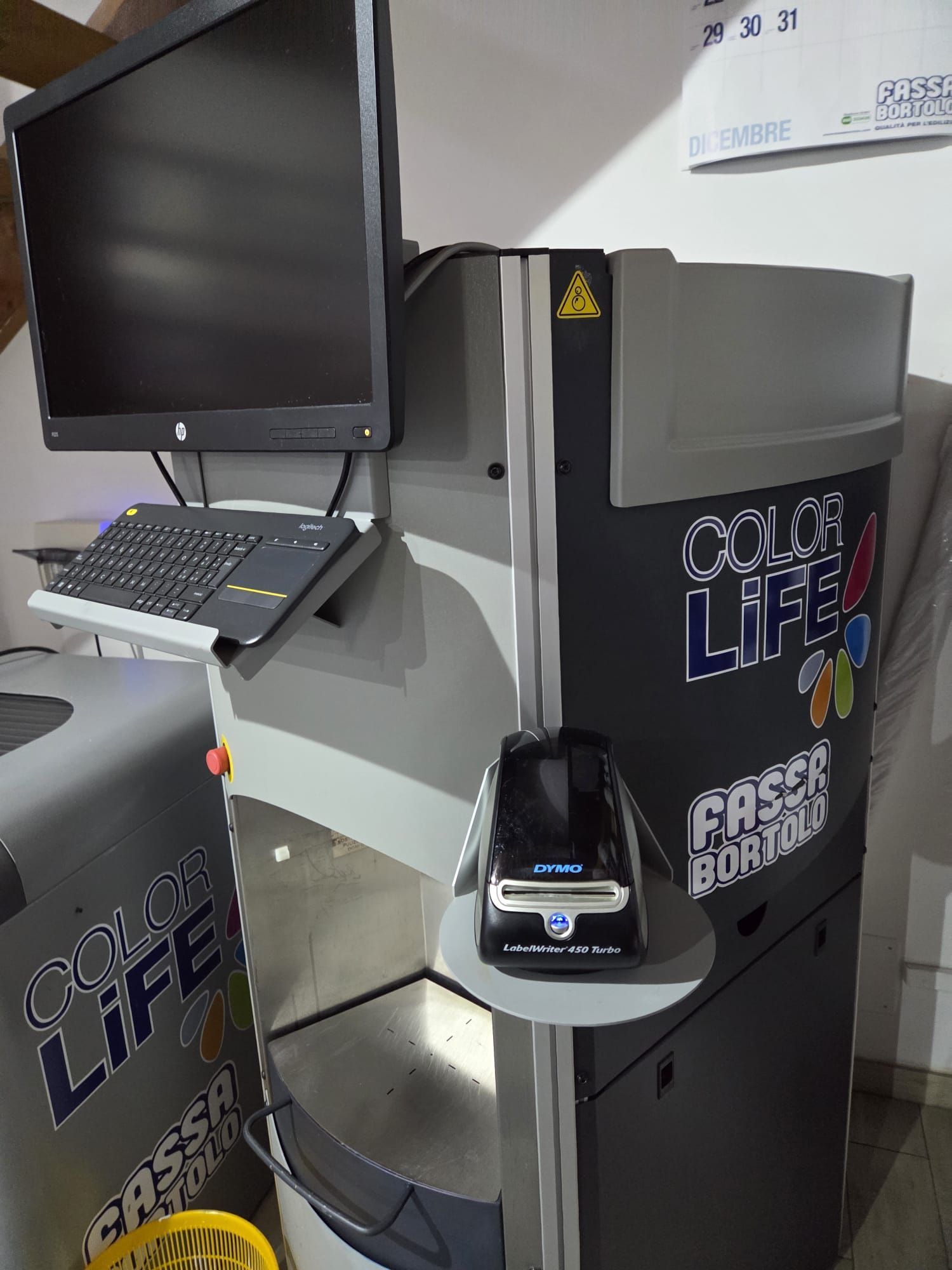 Un chiosco fotografico "Color Life" con computer, tastiera e scanner per codici a barre.